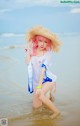 A woman in a straw hat is standing in the water.