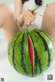 A woman holding a large watermelon in her hands.